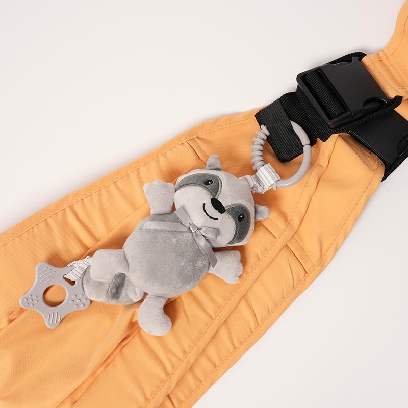 Raccoon mobile charm for babies attached onto a toddler carrier. 
